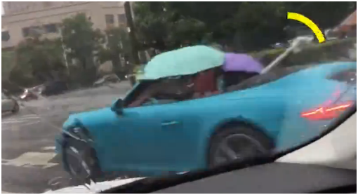 敞篷跑車打傘前行